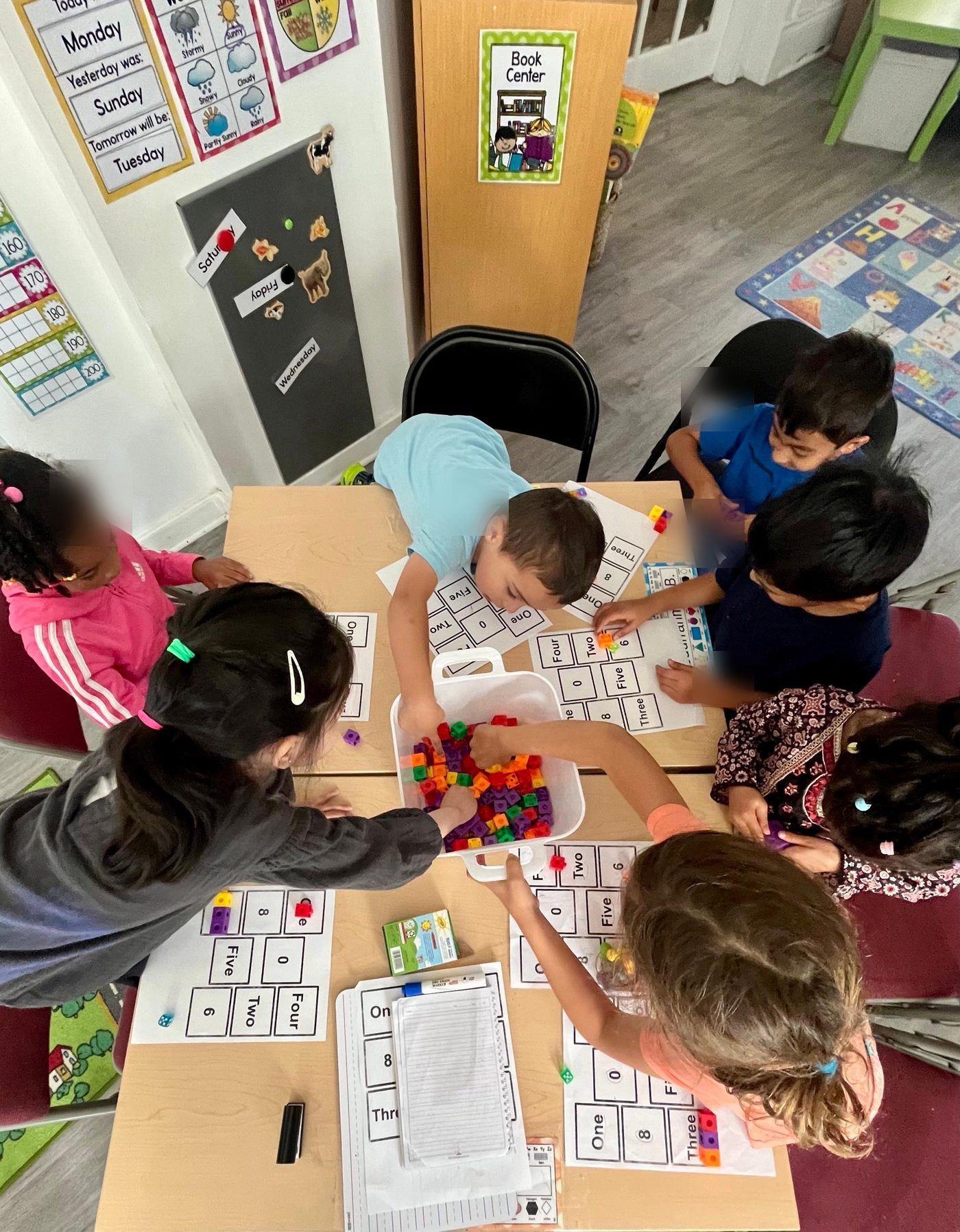 Students matching counting cubes to number boards in math class